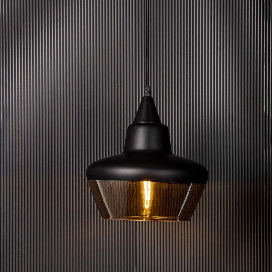 Elegant black and amber glass pendant light glowing beautifully against dark background for living room and bedroom use.