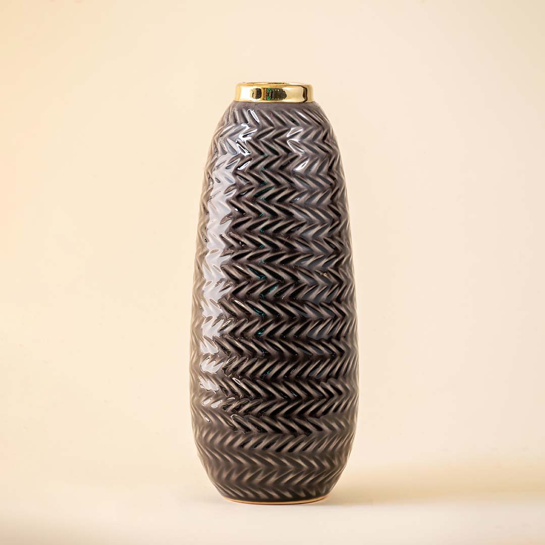 Grey ceramic decorative vase with embossed texture and elongated silhouette for sophisticated home decor displays.
