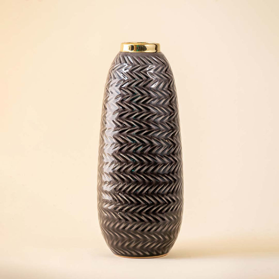 Grey ceramic decorative vase with embossed texture and elongated silhouette for sophisticated home decor displays.