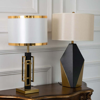 Modern black and gold table lamps with white drum shades shown together with lights off highlighting refined geometric design for upscale home decor.