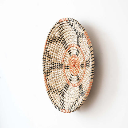 Side view of handwoven wall basket decor made of rustic natural fiber with boho geometric design for wall styling.