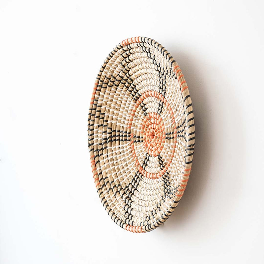 Side view of handwoven wall basket decor made of rustic natural fiber with boho geometric design for wall styling.
