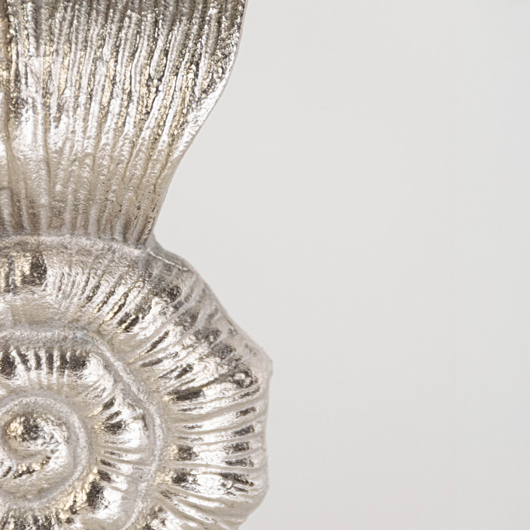 Closeup shell decor piece in silver finish with textured pattern for table decor or shelf styling contemporary home placement white background.