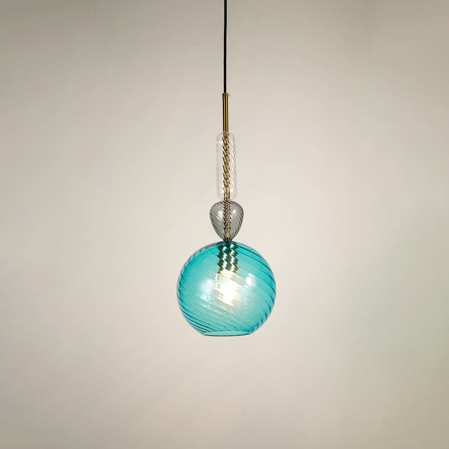 Blue glass pendant light glowing softly on white background showcasing modern design for stylish dining room and living space lighting.