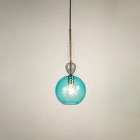 Blue glass pendant light glowing softly on white background showcasing modern design for stylish dining room and living space lighting.