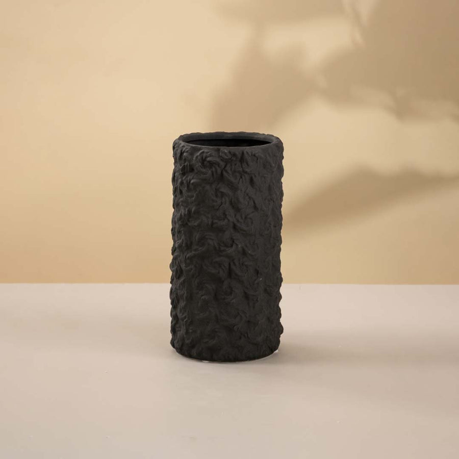 Black textured ceramic decorative vase with cylindrical form for tabletop styling and modern home decor displays.