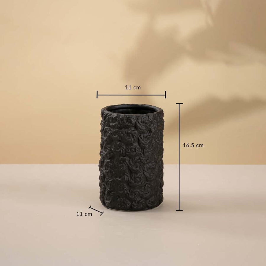 Black cylindrical ceramic vase featuring 22 cm height and 12 cm width displayed on a beige background.