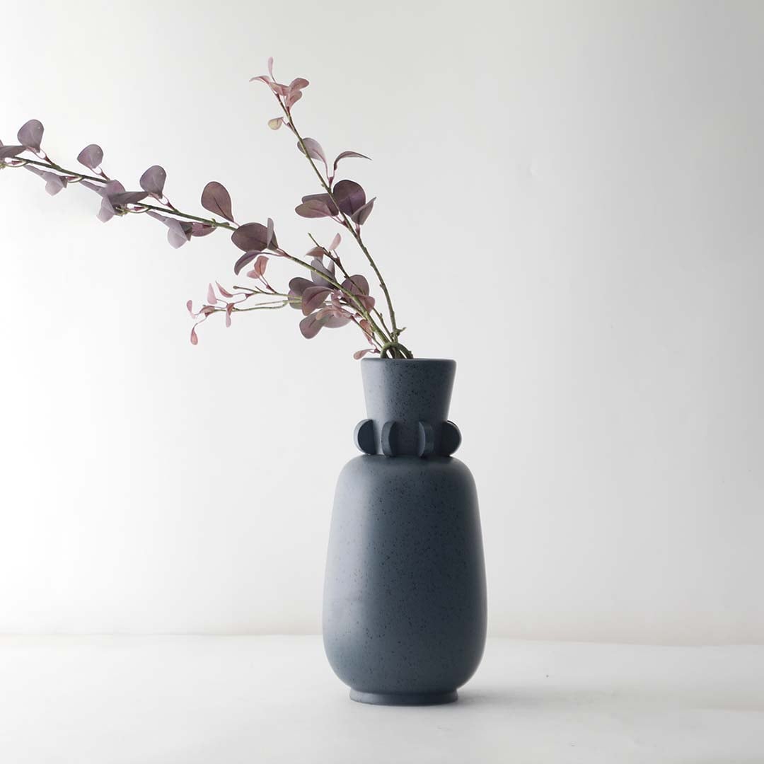 Elegant grey ceramic vase with ring neck detail and smooth speckled finish perfect for living room decoration.