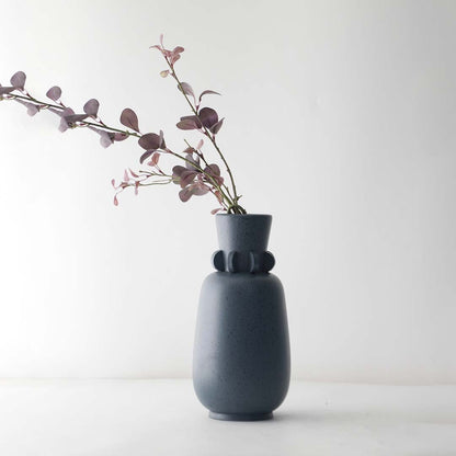 Elegant grey ceramic vase with ring neck detail and smooth speckled finish perfect for living room decoration.