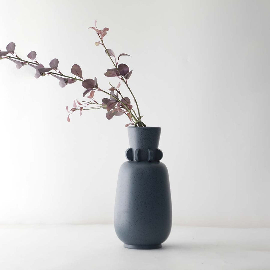 Elegant grey ceramic vase with ring neck detail and smooth speckled finish perfect for living room decoration.