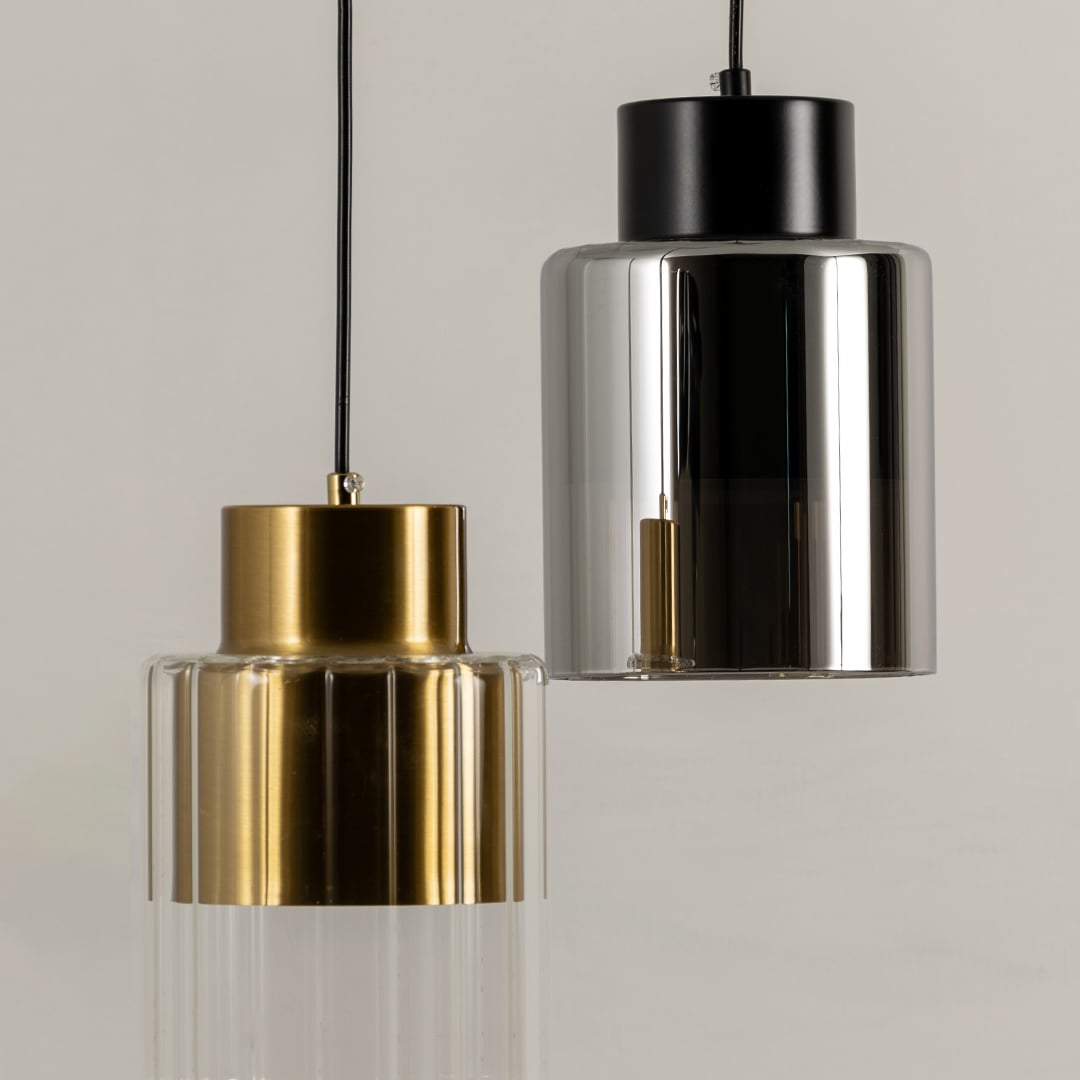 Gold and black metal pendant lights illuminated to highlight premium craftsmanship and contemporary decorative styling.