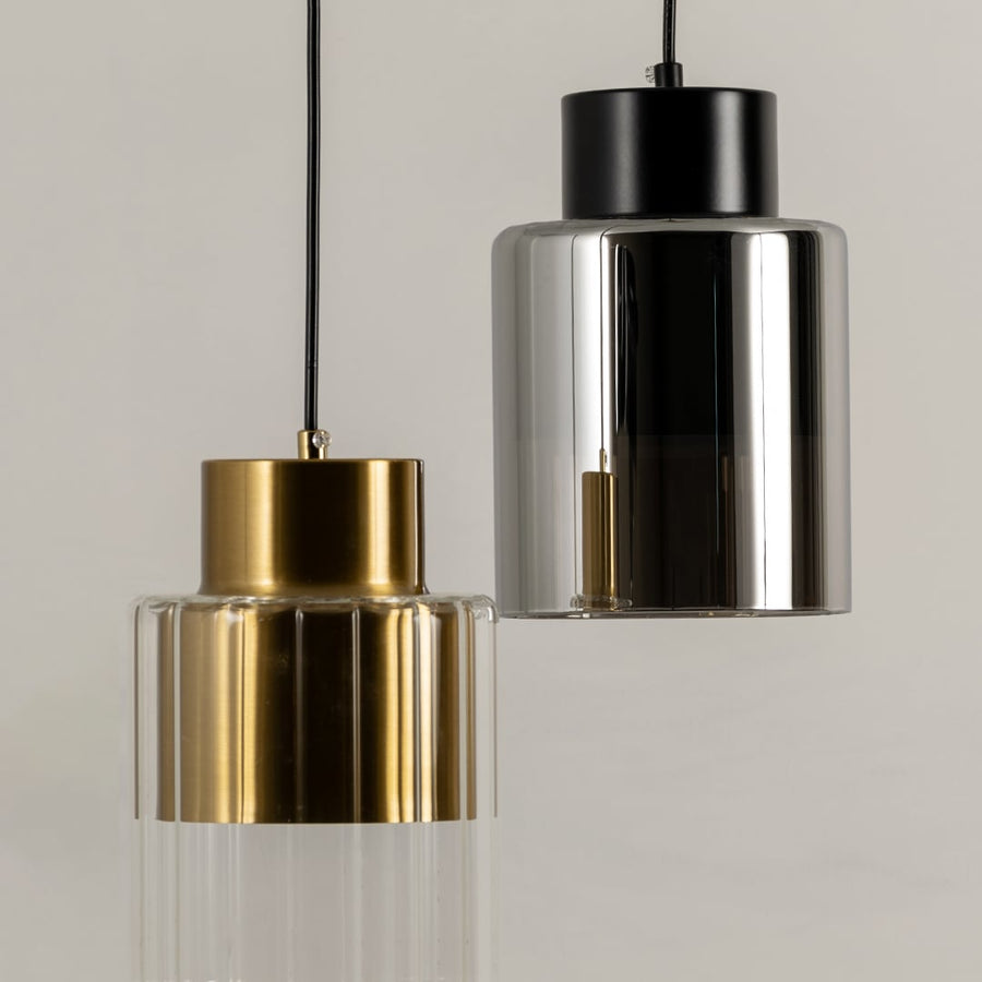 Gold and black metal pendant lights illuminated to highlight premium craftsmanship and contemporary decorative styling.