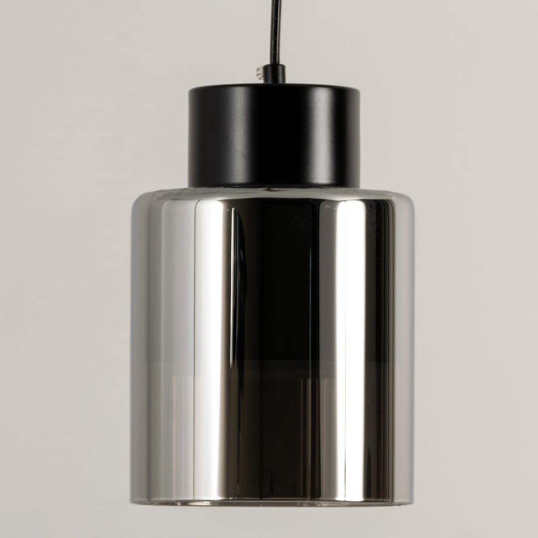 Smoke glass pendant light illuminated to showcase sleek modern ceiling lighting with reflective decorative appeal.