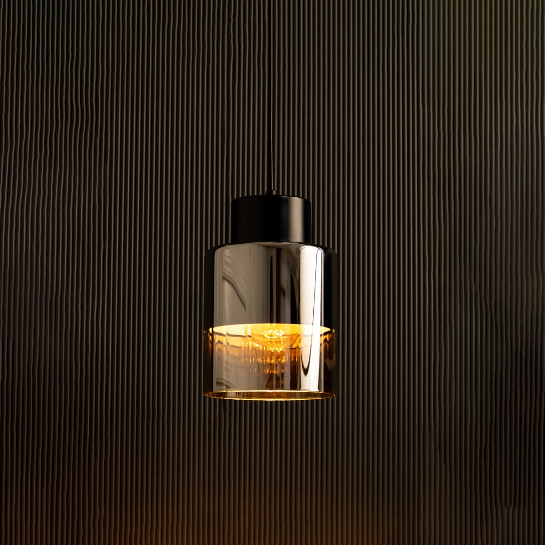 Shiny black metal pendant light illuminated against a dark background highlighting its mirror-like finish and elegant industrial tone.