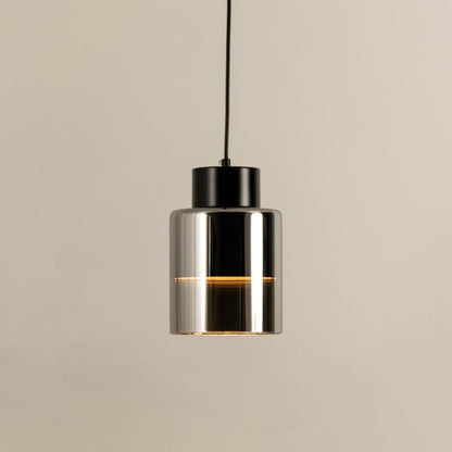 Black metal pendant light with clear glass diffuser illuminated to display sleek contemporary ceiling lighting style.