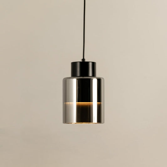 Black metal pendant light with clear glass diffuser illuminated to display sleek contemporary ceiling lighting style.