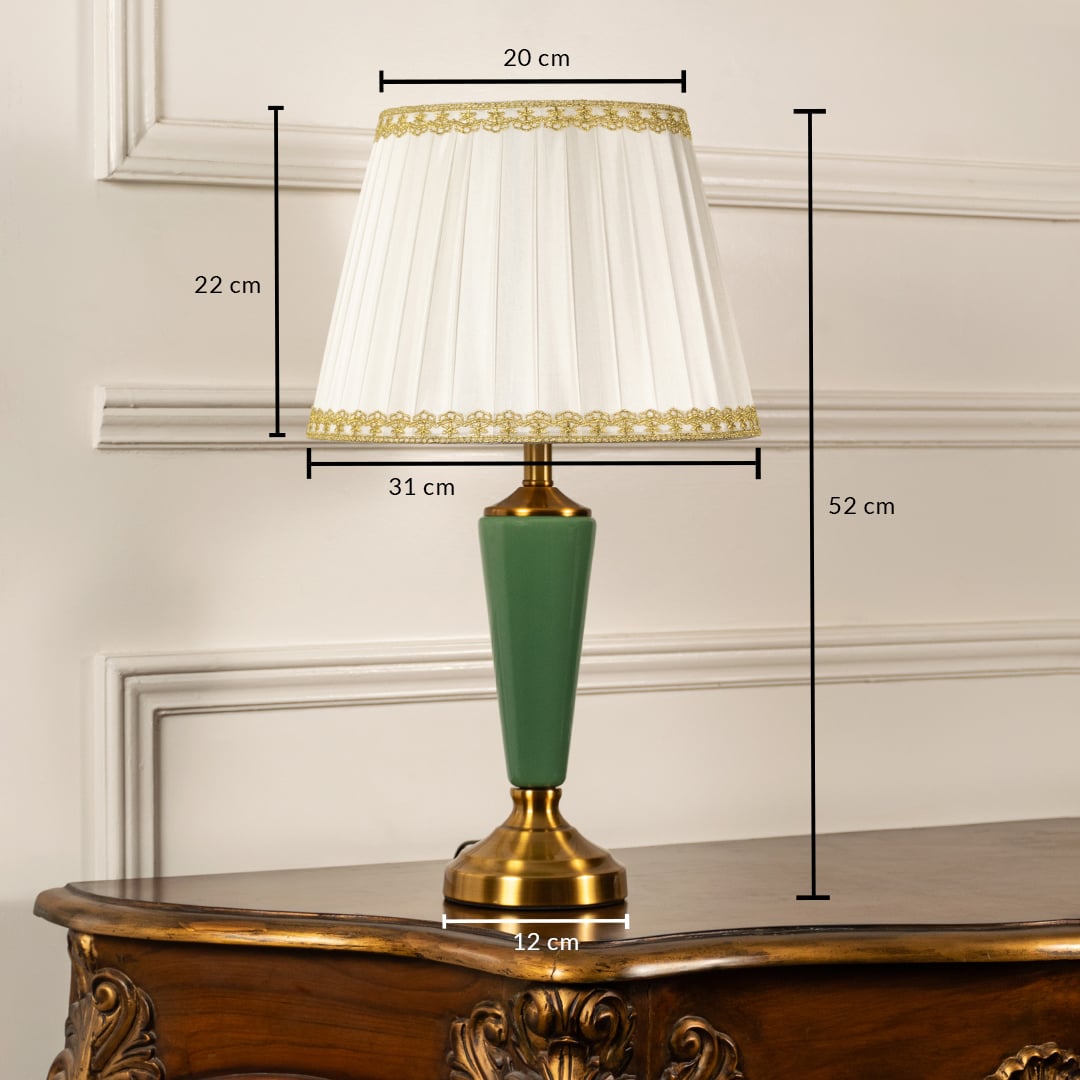 Table lamp with green metal base and white pleated shade shown with 20 cm top width 31 cm bottom width 12 cm base width and 52 cm height for accurate decor placement.