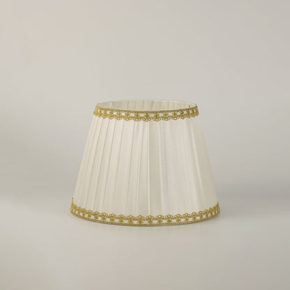 Table lamp with green metal base and pleated white shade presented on a clean white background for clear product detail.