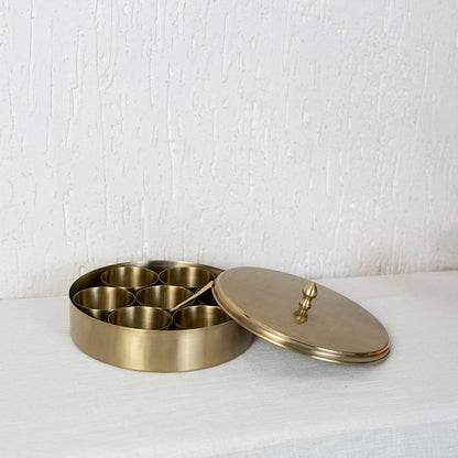 Brass spice container shown with closed lid and top knob placed centrally on white background for clean product view.