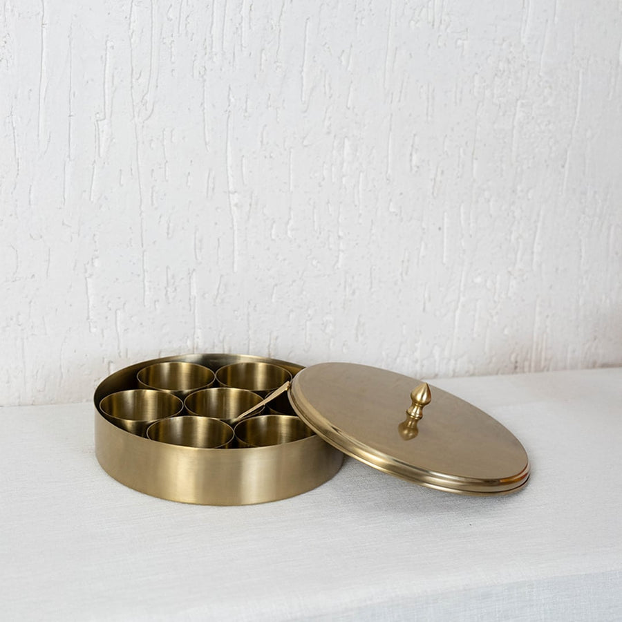 Brass spice container shown with closed lid and top knob placed centrally on white background for clean product view.