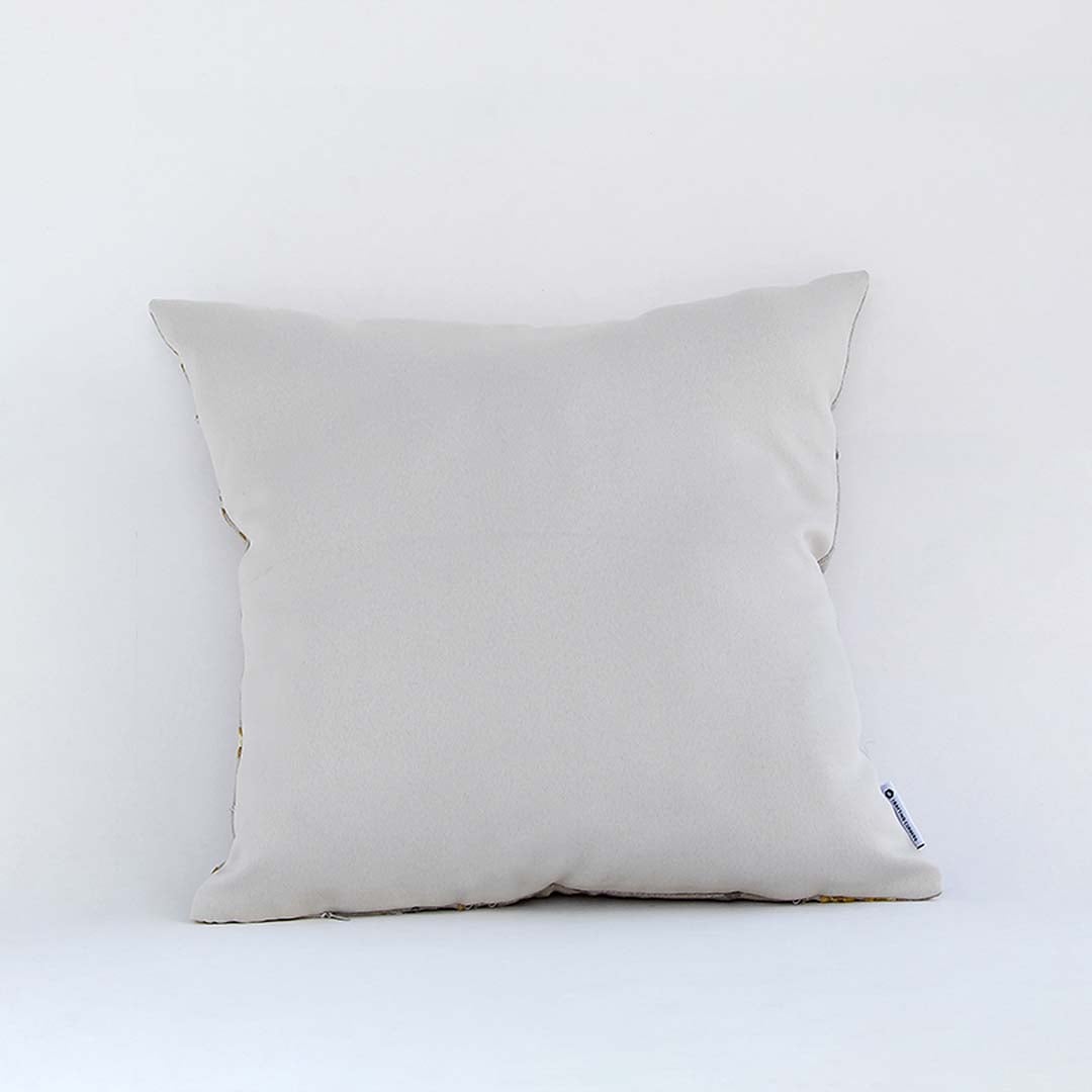 Side view of the embroidered cushion showing its filled structure and neat stitched edges.