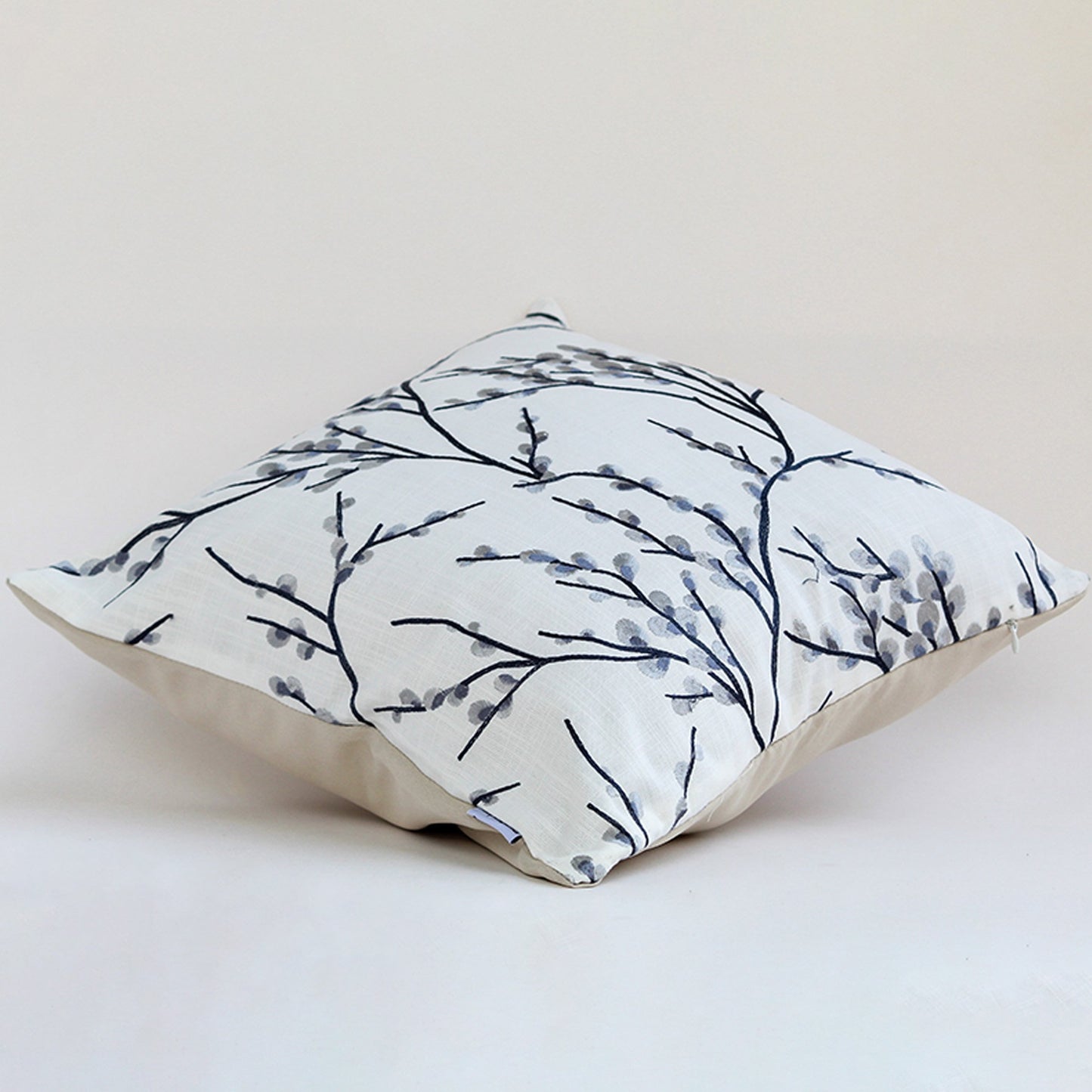 Alternate white background view of the grey botanical embroidered cushion highlighting its subtle texture.