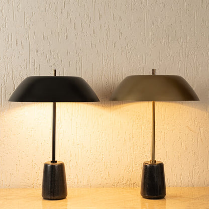 Pair of modern metal table lamps with dome shades casting warm ambient light for sophisticated interior decor styling.