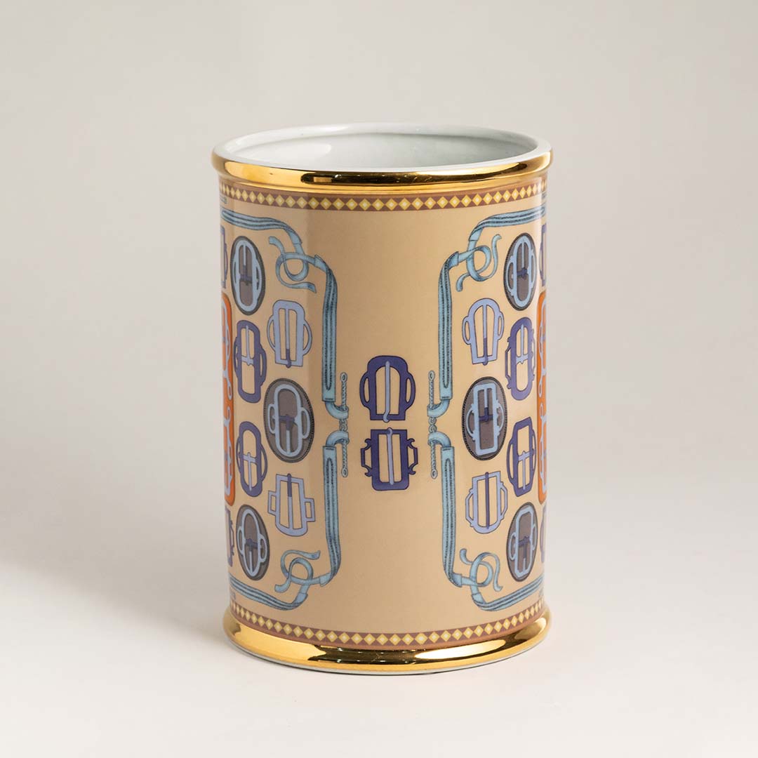Glossy ceramic holder with golden edges and bold orange blue pattern highlighted on white background decor.