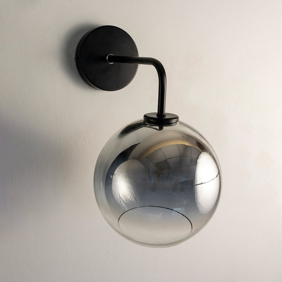Smoky glass globe wall light with black metal arm displayed on white background ideal for modern home interiors.