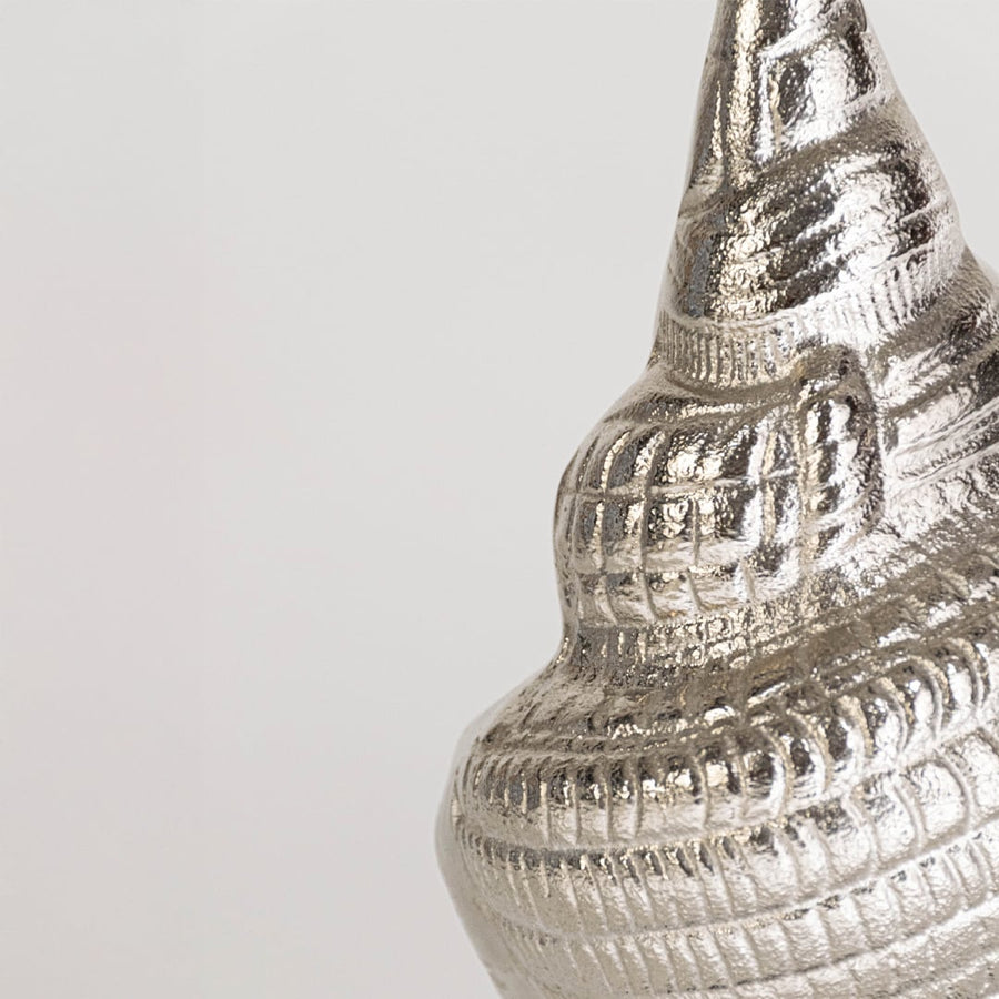 Closeup of silver metal conch sculpture showing detailed ridged texture and elegant form ideal for coastal inspired modern interior decor.