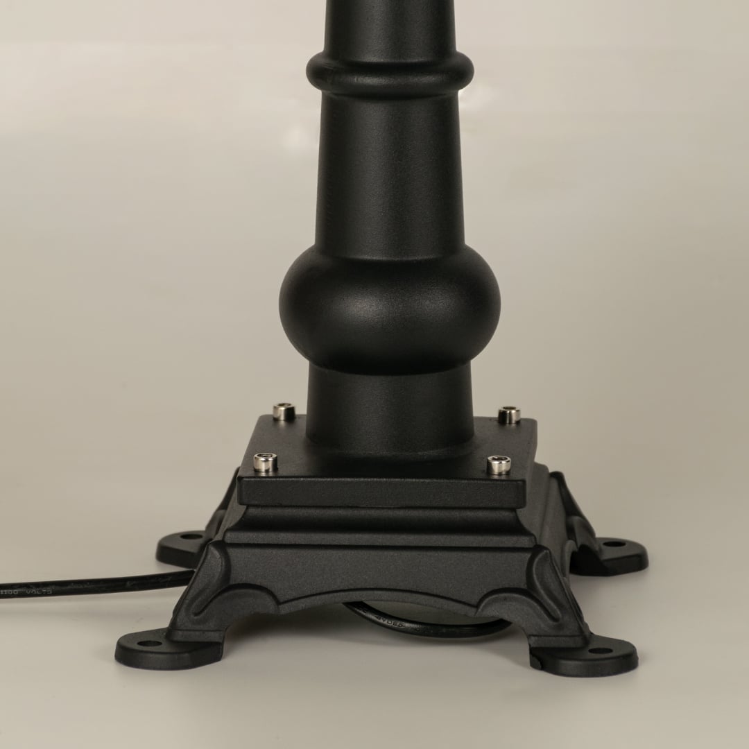 A focused closeup of the lantern top showing the finial structure smooth metal roof and detailed patterned frame that surrounds the frosted glass panel beautifully.