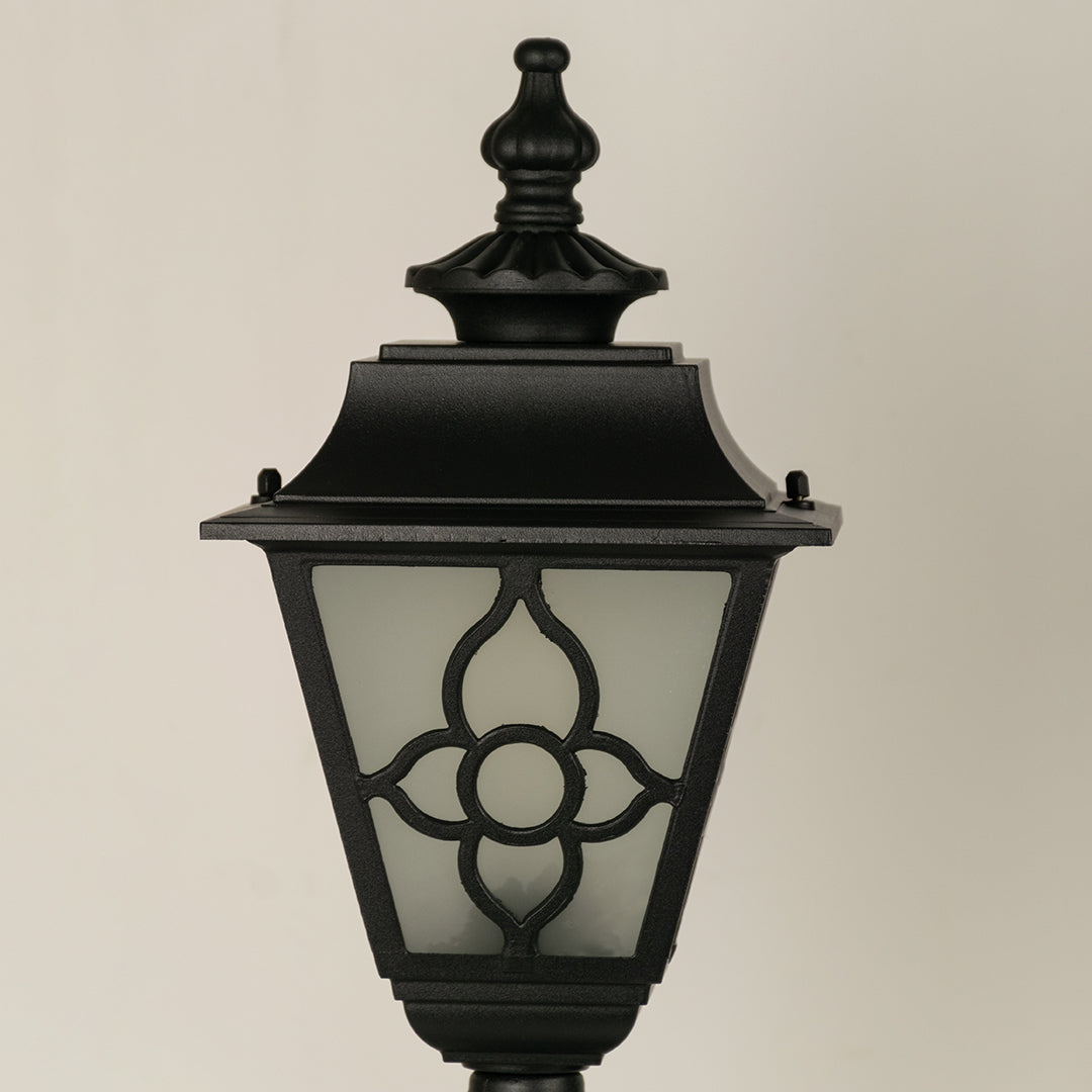 Closeup of black outdoor wall light with floral metal detailing for elegant exterior decor styling.