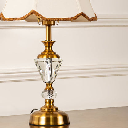 Closeup of gold and crystal base with cream fabric shade highlighting fine detailing and craftsmanship table lamp.