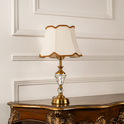 Gold and crystal table lamp with cream fabric shade turned off against white background modern decor table lamp.