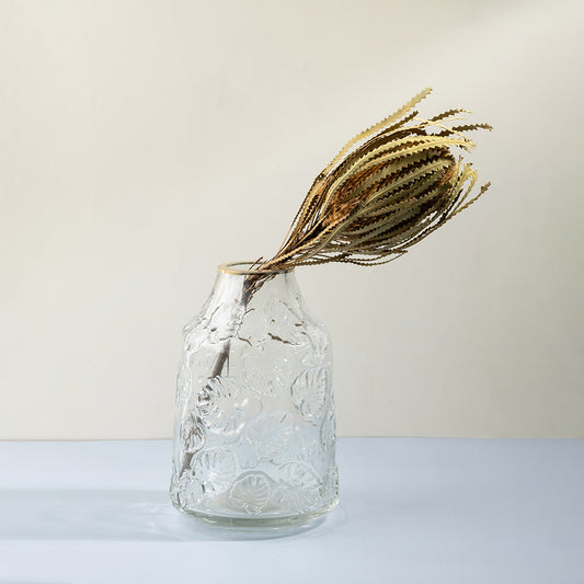 Clear textured glass decorative vase with dried stems for tabletop styling and minimalist home decor displays.