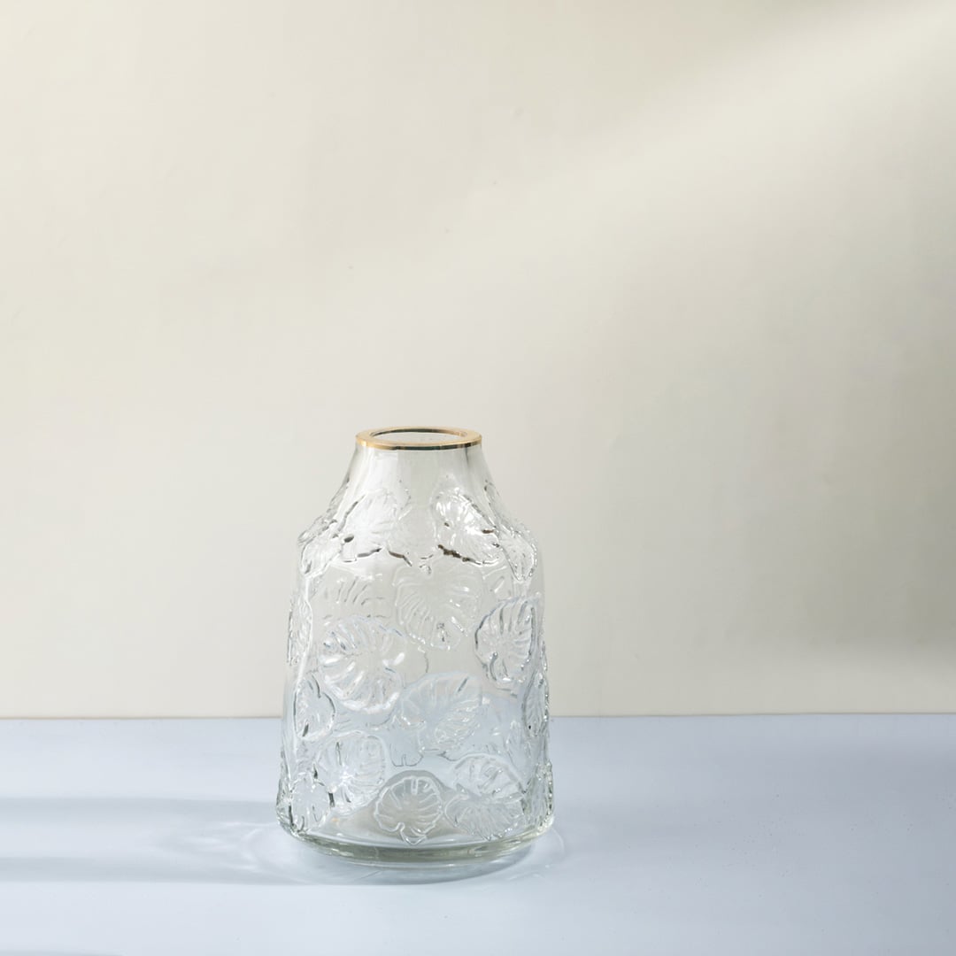 Transparent embossed glass vase with leaf pattern for modern home styling White background Image.