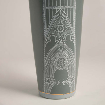 Detailed closeup of ceramic jar in green with golden lid and fine white artwork for stylish luxury decoration.