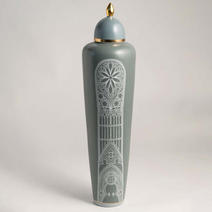 Elegant matte green ceramic jar with golden detailing and white artistic pattern on white background for interiors.
