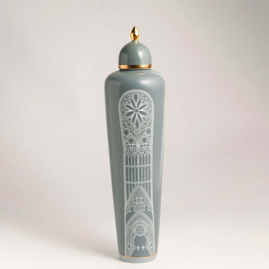 Elegant green ceramic jar with white artistic detailing and golden lid on white background for modern interiors.