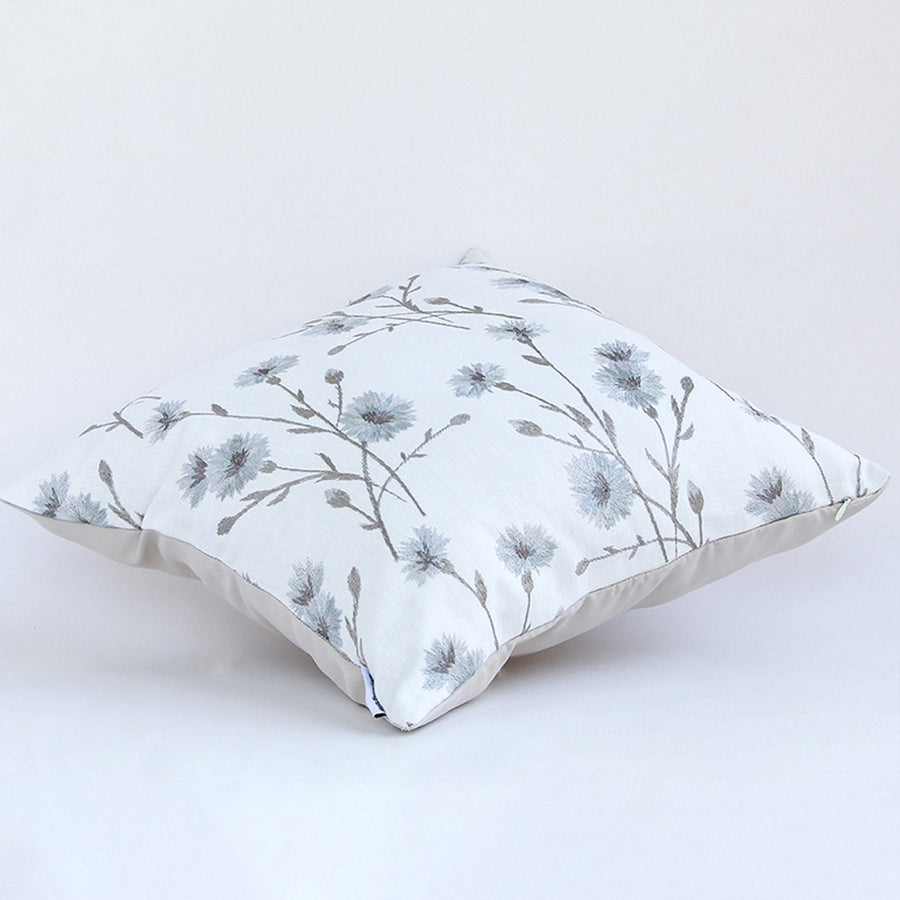 Elegant blue floral cushion placed against a white background highlighting its delicate embroidered design.