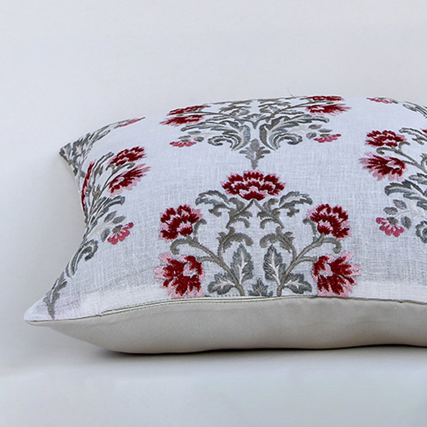 Closeup view of cotton cushion embroidery showing detailed red and grey floral stitching and soft textured fabric perfect for elegant home decor accents.