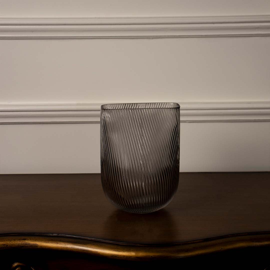 Contemporary smoky gray decorative glass vase featuring vertical ribbed detailing and rounded base shown on white background.