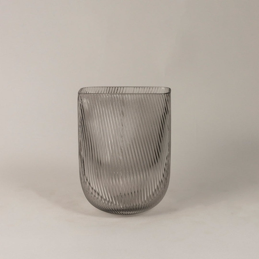 Smoky gray ribbed glass vase with a modern curved design displayed on a plain white background.