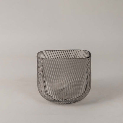 Modern ribbed glass vase in smoky gray tone displayed on a white background emphasizing its sleek and stylish form.