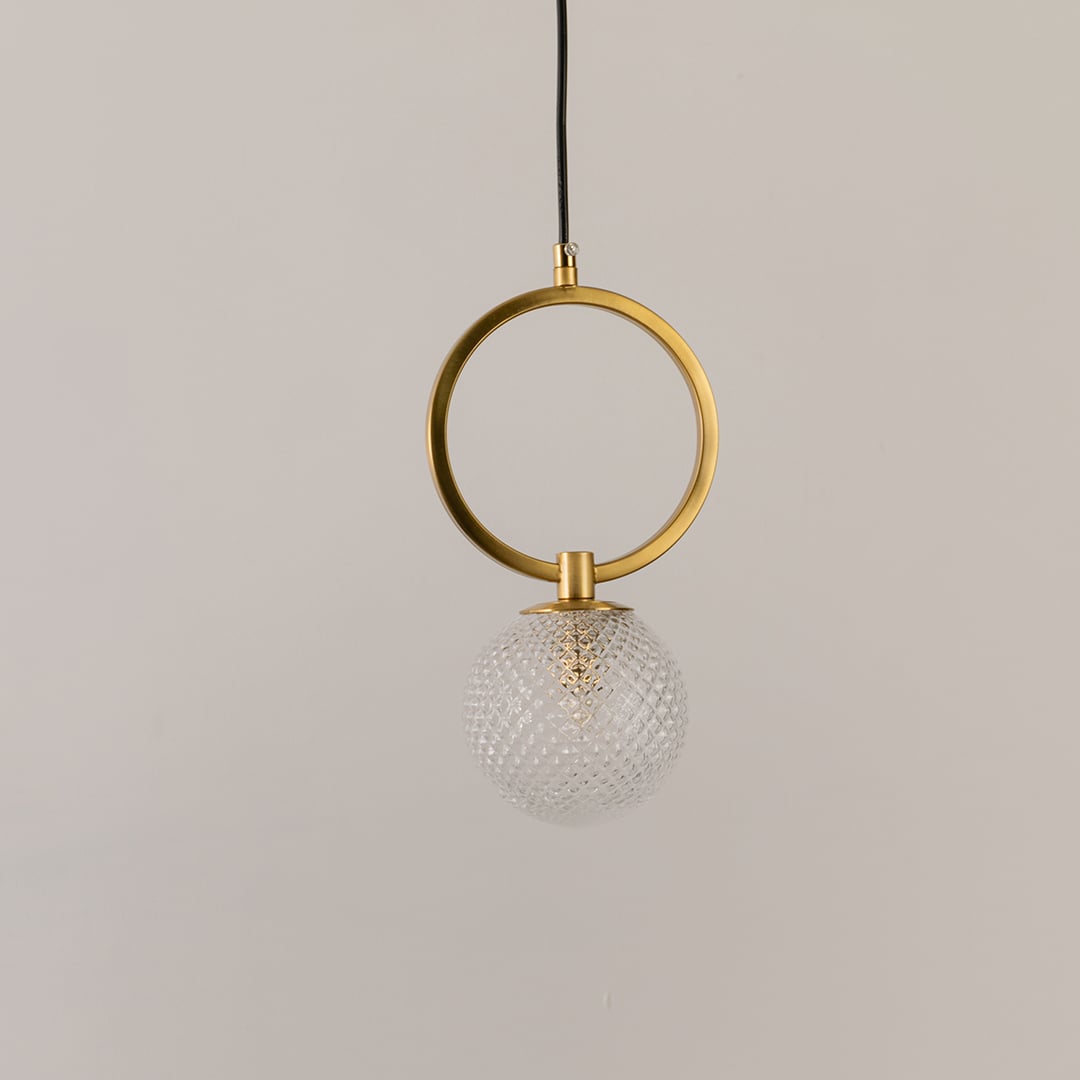 Gold ring pendant light on a white background with the light off highlighting its sculptural modern form and glass detailing.