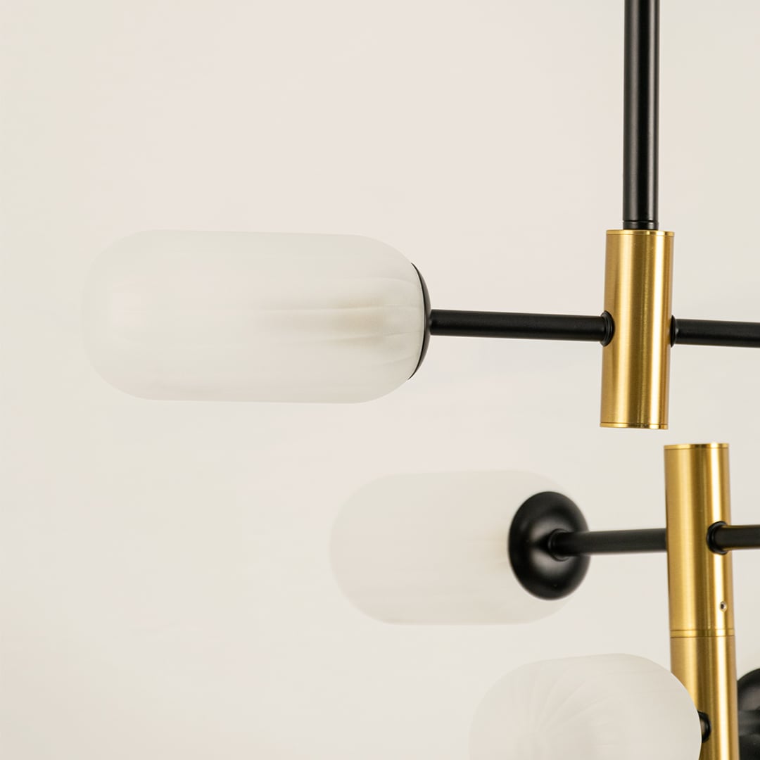 Close view of gold and black chandelier showing frosted glass detailing metallic finish and refined minimalist craftsmanship.