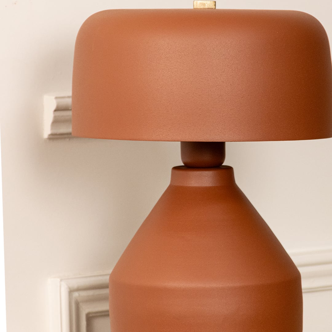 Terracotta ceramic table lamp with rounded shade and handcrafted finish showcasing contemporary decorative elegance.