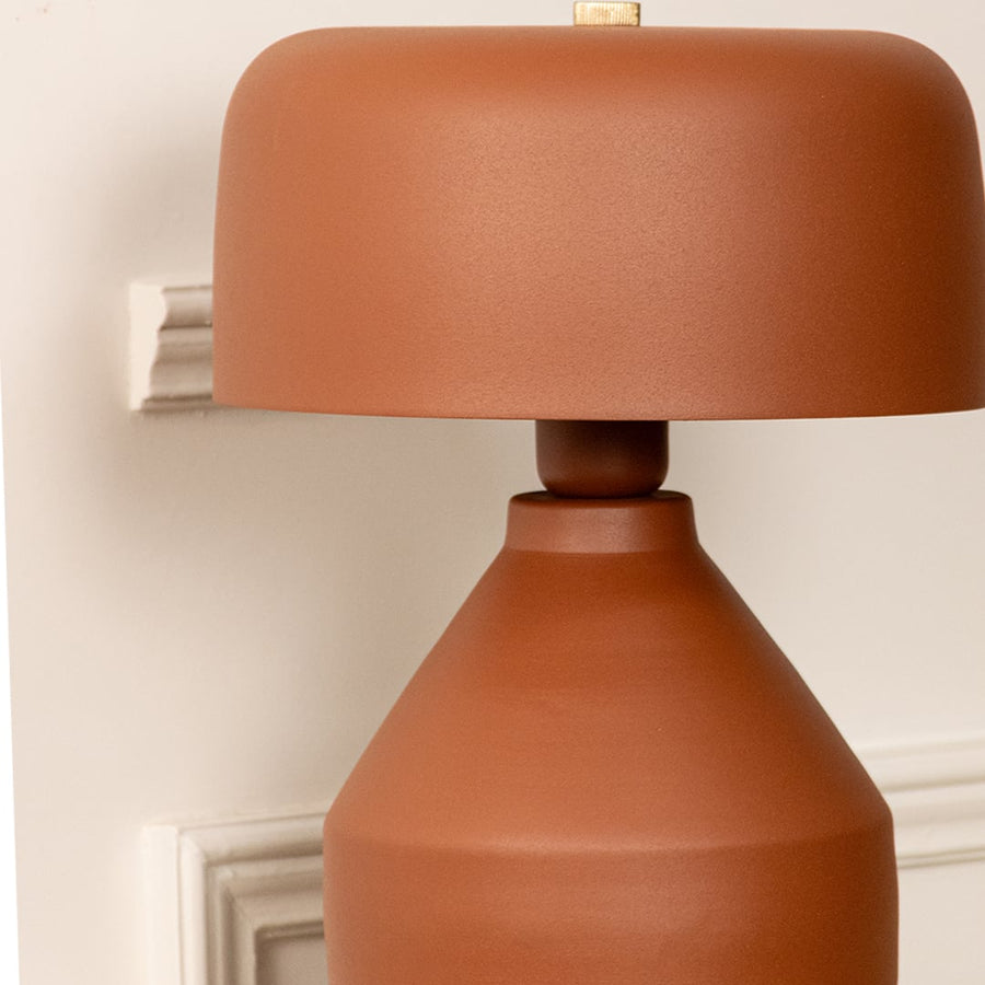 Terracotta ceramic table lamp with rounded shade and handcrafted finish showcasing contemporary decorative elegance.