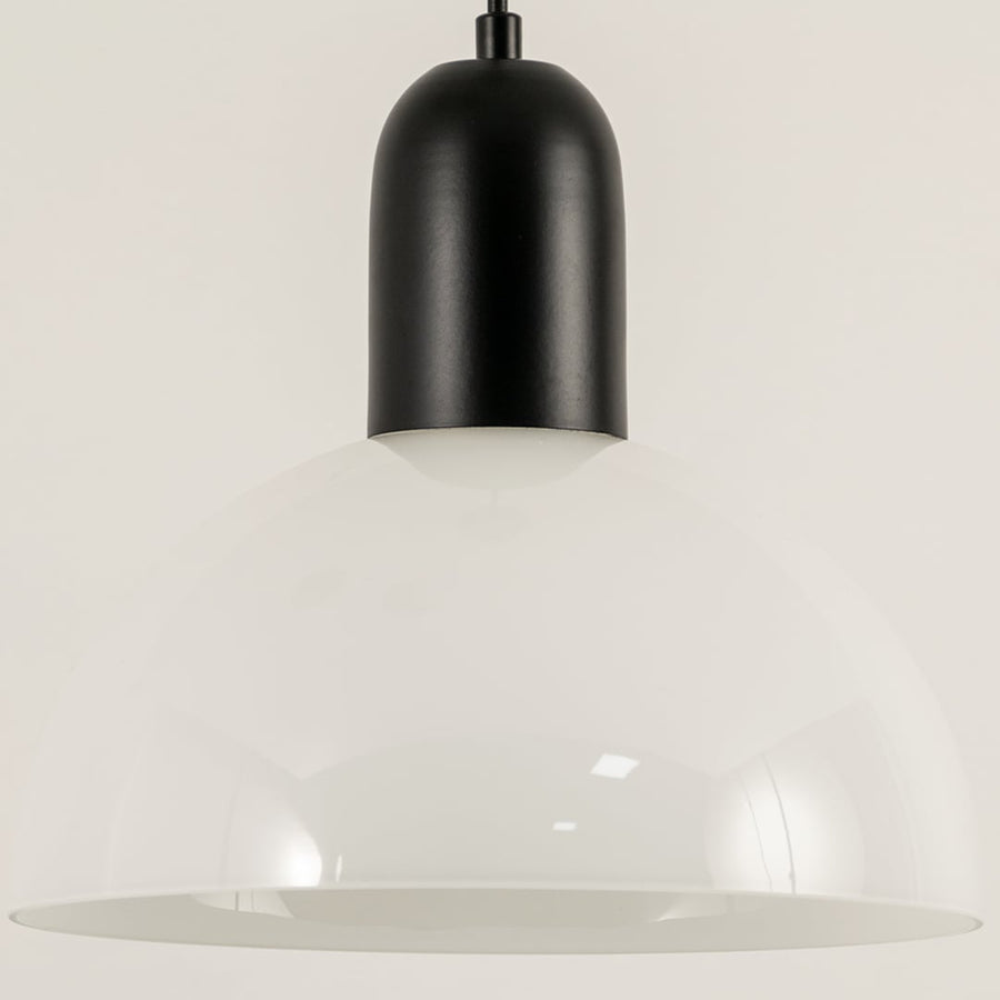 Black and white metal pendant light illuminated to display contemporary ceiling lighting with minimalist modern styling.