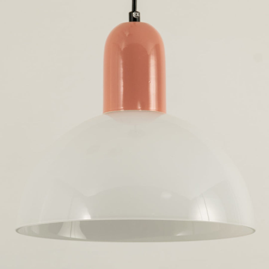 A closeup of dome pendant light with a soft peach top shown in close view against a smooth beige background creating gentle ambient lighting and elegant décor.